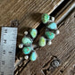 Turquoise stone jewelry piece on a wooden surface with a ruler for scale.
