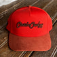 Orange cap with 'Classic Cowboy' logo on a wooden surface