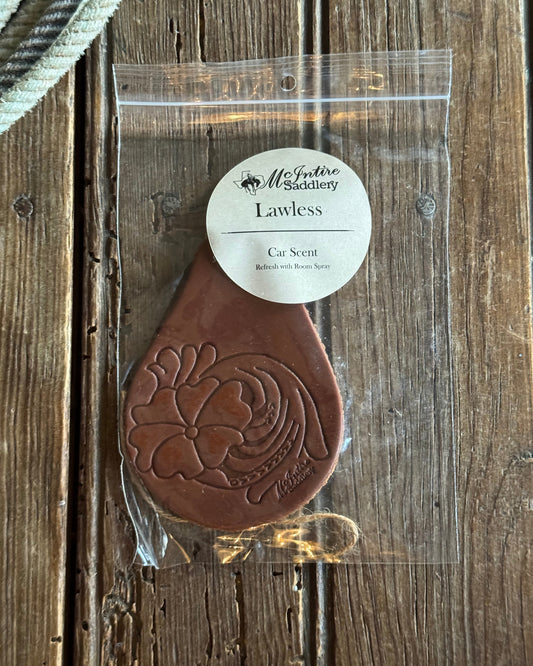 Brown leather guitar pick with a clear plastic cover on a wooden surface