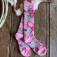 Pair of pink and gray floral-patterned socks on a wooden surface 