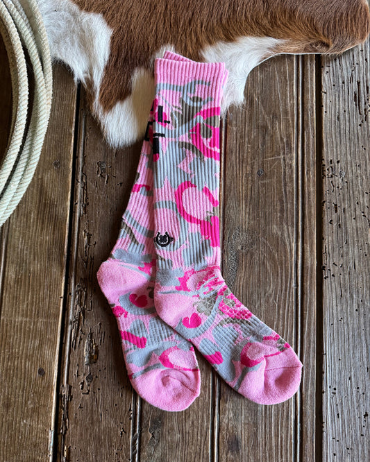 Pair of pink and gray floral-patterned socks on a wooden surface 