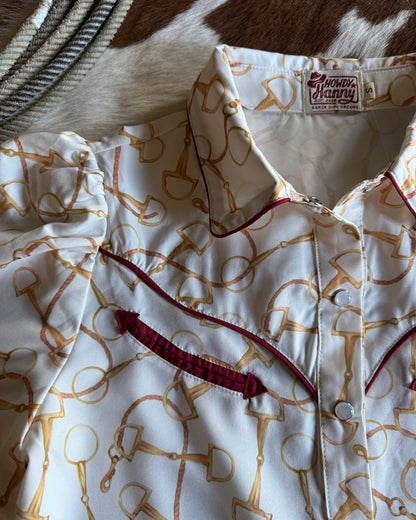 Close-up of a shirt with a pattern and brand label, partially on a cowhide surface.
