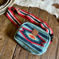 Small pouch with colorful strap on a wooden surface