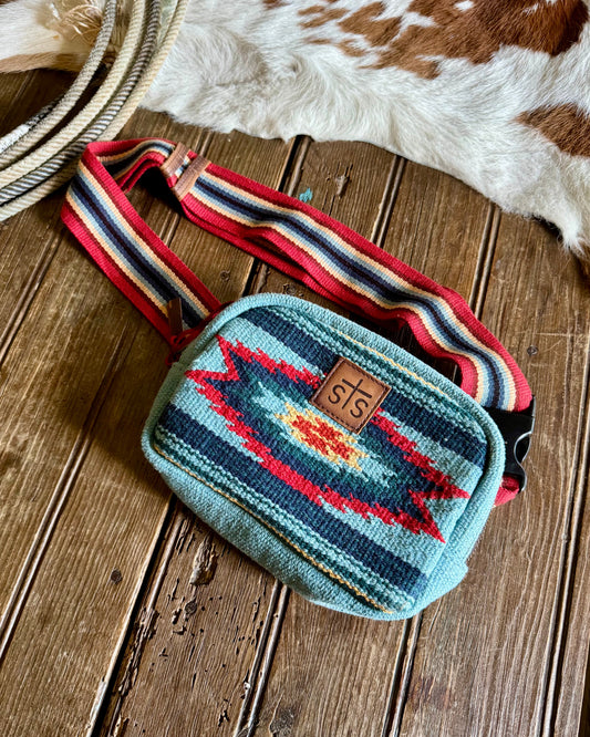 Small pouch with colorful strap on a wooden surface