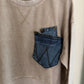 Beige sweatshirt with a blue denim pocket design on a white background