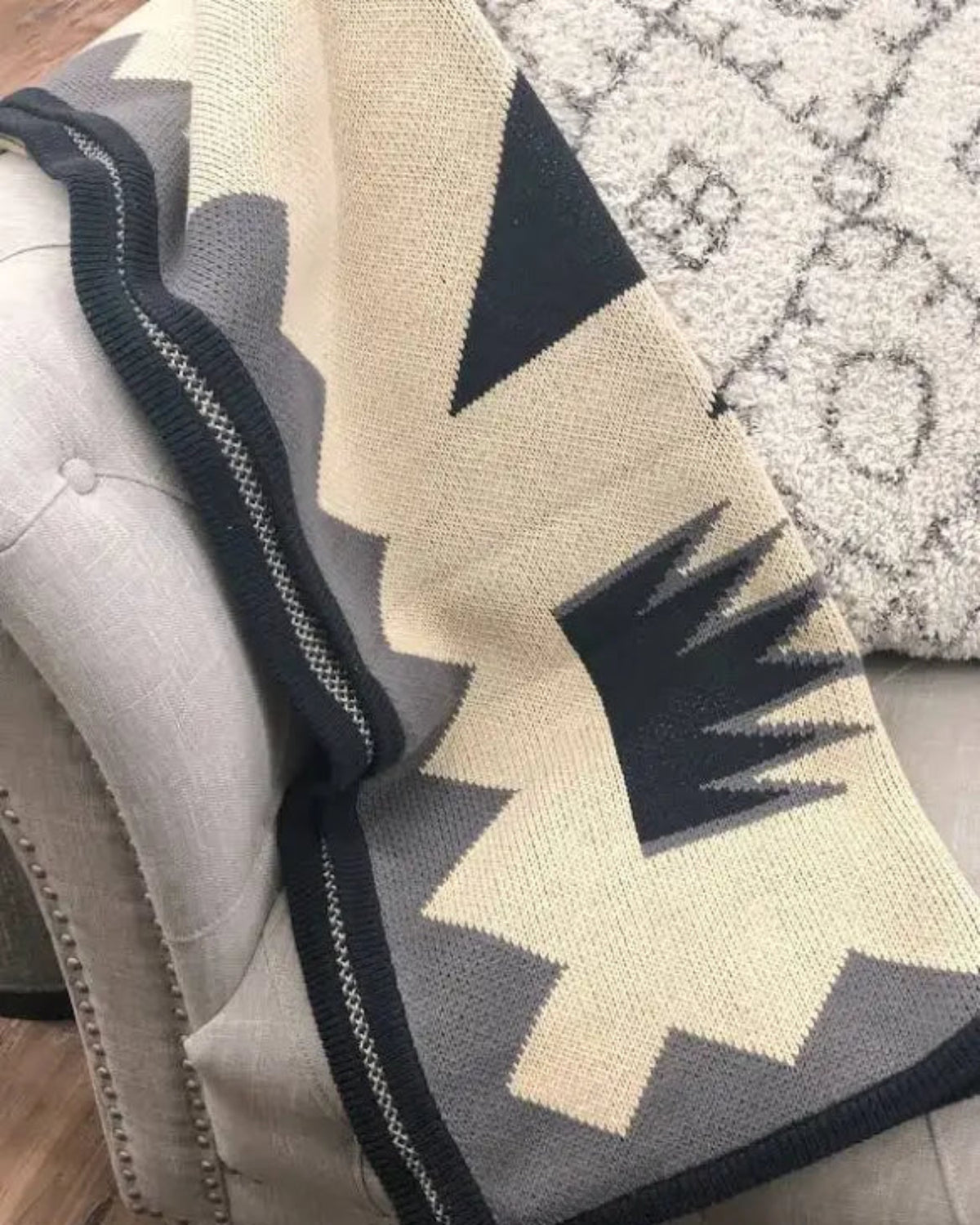 Textured blanket with geometric pattern draped over a surface