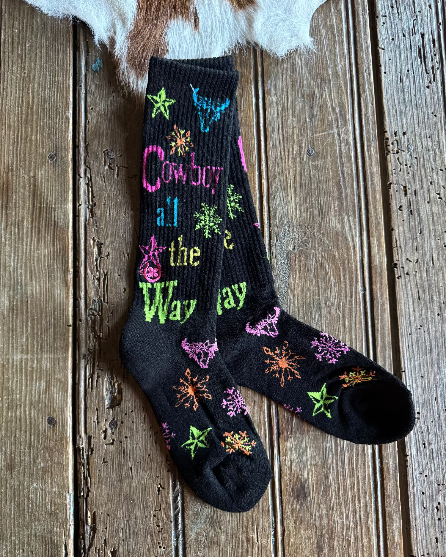 Black socks with colorful designs on a wooden surface