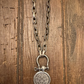 Silver necklace with a pendant on a wooden surface