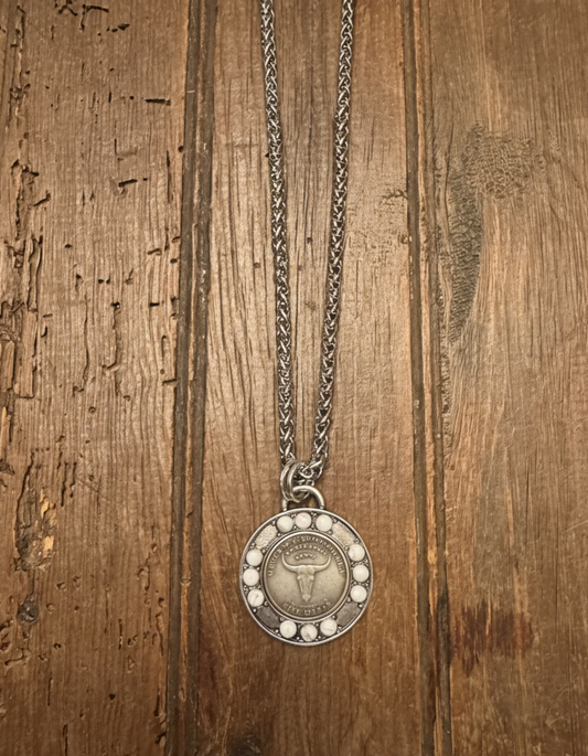 Silver necklace with a round pendant on a wooden surface