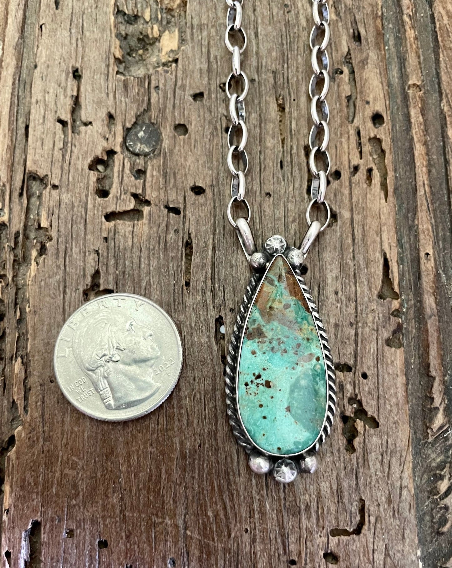 Close up of Kingman Turquoise teardrop necklace with quarter for size comparison