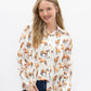 Woman wearing a white blouse with horse print and blue jeans on a white background