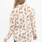 A woman viewed from behind wearing a long-sleeve button-up shirt with an all-over print of brown and black horses on a white background, paired with dark blue jeans against a plain white studio background.