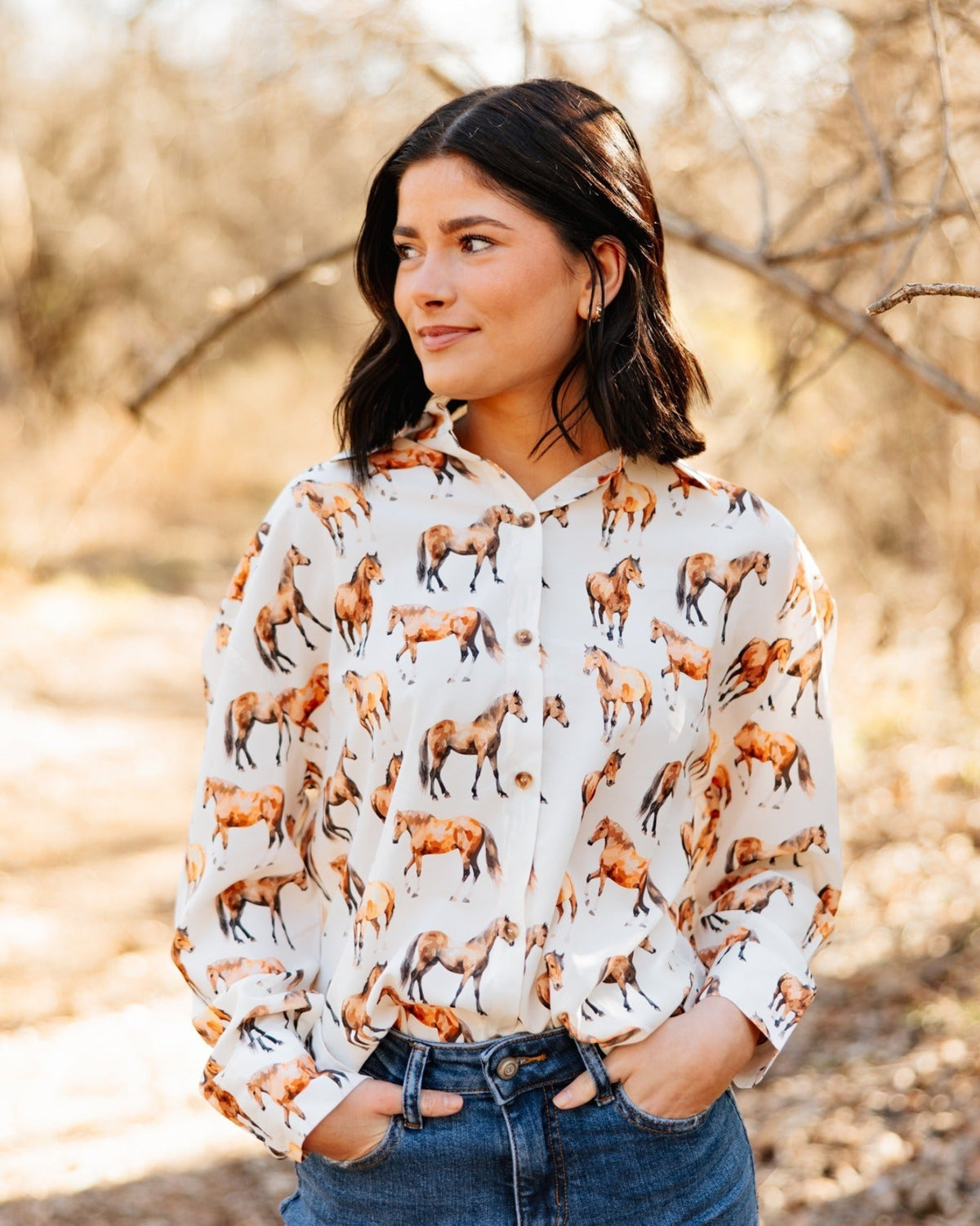 Woman wearing a blouse with horse pattern in a natural setting