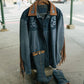 Blue denim jacket with brown leather accents on a mannequin outdoors.