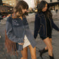 Two women walking on a city street at dusk.